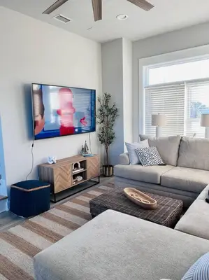 a living room with a couch and a flat screen tv at Barefoot Dreams! in Panama City Beach