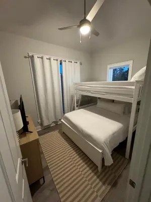 a bedroom with a bunk bed and a ceiling fan at Barefoot Dreams! in Panama City Beach