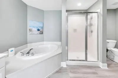 a white bathroom with a tub and a shower at Tidewater 2308 by Emerald Coast Retreats in Panama City Beach
