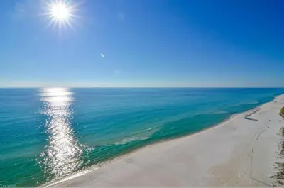 an aerial view of a beach with the sun in the sky at Beach Place Seconds to Beach 6 in Panama City Beach