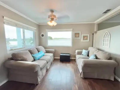 a living room with two couches and a window at Beach Place Seconds to Beach 6 in Panama City Beach
