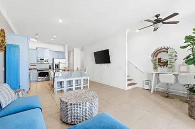 a living room with a blue couch and a kitchen at Beach House - Sea La Vie by Panhandle Getaways in Panama City Beach