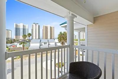 a balcony with a chair and a view of the city at Beach House - Sea La Vie by Panhandle Getaways in Panama City Beach