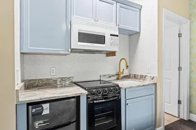 a kitchen with white cabinets and a stove top oven at Beach House - Sea La Vie by Panhandle Getaways in Panama City Beach
