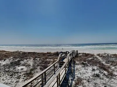 a wooden walkway to the beach with the ocean at Resting Beach Face in Panama City Beach