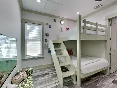 a bunk bed room with two bunk beds and a couch at Resting Beach Face in Panama City Beach