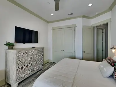 a bedroom with a large bed and a flat screen tv at Resting Beach Face in Panama City Beach