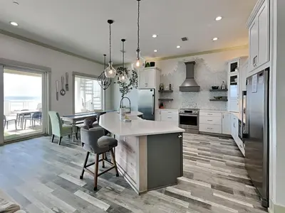 a kitchen with white cabinets and a table with chairs at Resting Beach Face in Panama City Beach