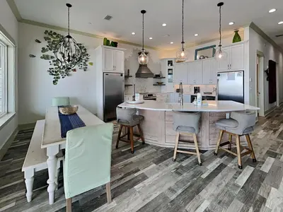 a kitchen with a large island and a table and chairs at Resting Beach Face in Panama City Beach