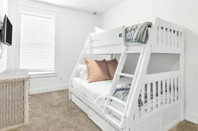 a bedroom with a white bunk bed with a ladder at Salty Sons 4 BR and just minutes to the Beach Rosemary and 30Avenue in Inlet Beach
