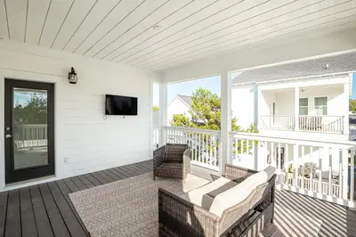 a screened porch with a flat screen tv at Salty Sons 4 BR and just minutes to the Beach Rosemary and 30Avenue in Inlet Beach