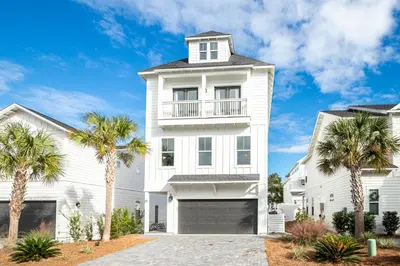 a white house with palm trees in front of it at Salty Sons 4 BR and just minutes to the Beach Rosemary and 30Avenue in Inlet Beach