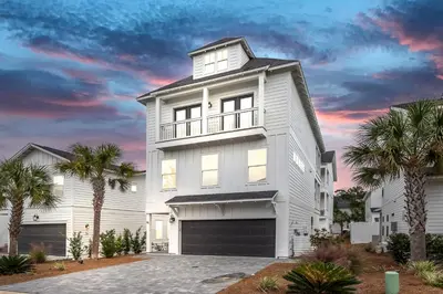 a white house with palm trees in front of it at Salty Sons 4 BR and just minutes to the Beach Rosemary and 30Avenue in Inlet Beach