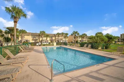 a swimming pool with lounge chairs and a palm tree at Gulf Highlands 146 by Book That Condo in Panama City Beach