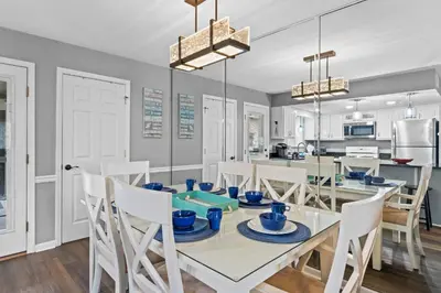 a kitchen and dining room with a glass table and chairs at Gulf Highlands 146 by Book That Condo in Panama City Beach