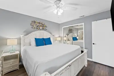 a bedroom with a large white bed with blue pillows at Gulf Highlands 146 by Book That Condo in Panama City Beach