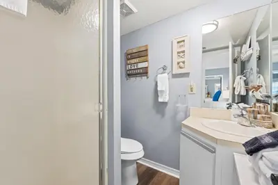 a bathroom with a sink and a toilet and a mirror at Gulf Highlands 146 by Book That Condo in Panama City Beach