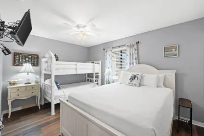 a bedroom with a white bed and bunk beds at Gulf Highlands 146 by Book That Condo in Panama City Beach