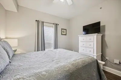 a bedroom with a bed and a dresser and a television at Majestic Beach Resort 1411-1 by Book That Condo in Panama City Beach