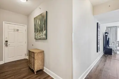 a hallway with white walls and a painting on the wall at Majestic Beach Resort 1411-1 by Book That Condo in Panama City Beach