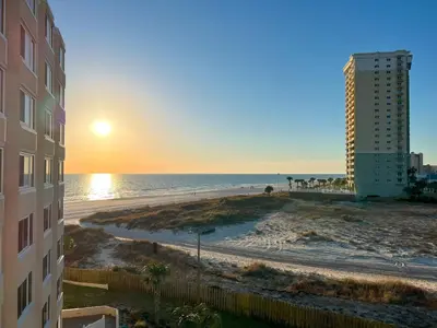 a view of the beach at sunset from a building at Beachfront Studio - Perfect Location - Free Beach Chairs in Panama City Beach