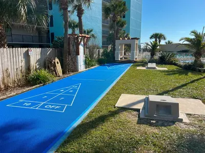 a blue basketball court with a tv on the grass at Beachfront Studio - Perfect Location - Free Beach Chairs in Panama City Beach