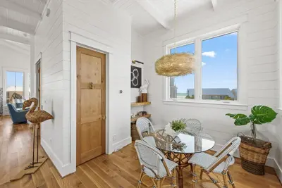 a dining room with a table and chairs and a window at Salt & Light - 5 BR, Sleeps 18, Gulf & Lake Views, Game Room & Bikes in Seagrove Beach