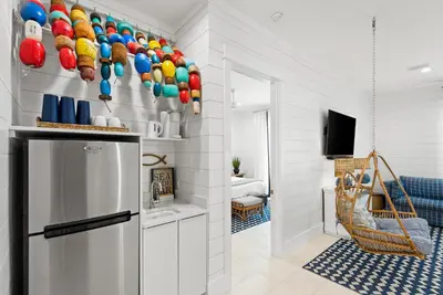 a kitchen with a refrigerator with colorful bowls on the wall at Salt & Light - 5 BR, Sleeps 18, Gulf & Lake Views, Game Room & Bikes in Seagrove Beach