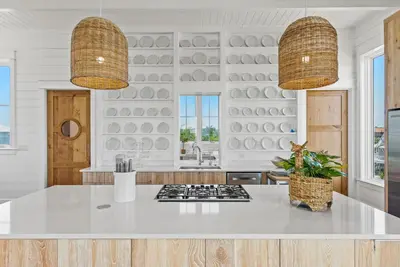a kitchen with a white counter and two pendant lights at Salt & Light - 5 BR, Sleeps 18, Gulf & Lake Views, Game Room & Bikes in Seagrove Beach
