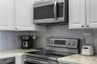 a kitchen with a stove and a microwave at Sunbird Resort! Awe-inspiring Views Throughout! hosted by Dolce Vita Getaways PCB in Panama City Beach