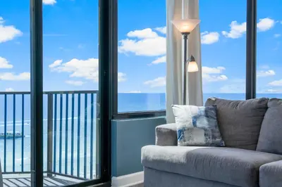 a living room with a couch and large windows at Sunbird Resort! Awe-inspiring Views Throughout! hosted by Dolce Vita Getaways PCB in Panama City Beach