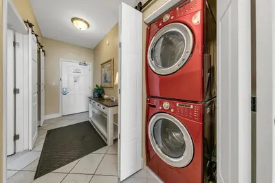 a washer and dryer in a room with a hallway at Aqua Resort 906 by Emerald Coast Retreats in Panama City Beach