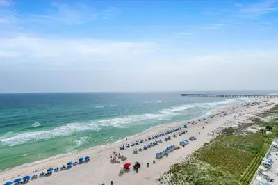 a beach with many umbrellas and the ocean at Aqua Resort 906 by Emerald Coast Retreats in Panama City Beach
