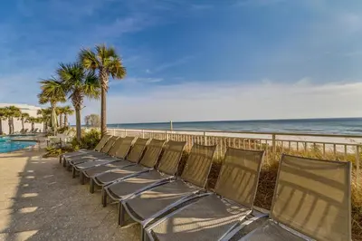 a row of chairs sitting next to the beach at Aqua Resort 906 by Emerald Coast Retreats in Panama City Beach