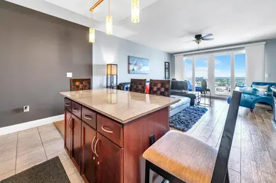 a living room with a kitchen and a living room with a couch at Laketown Wharf 1829 by Emerald Coast Retreats in Panama City Beach