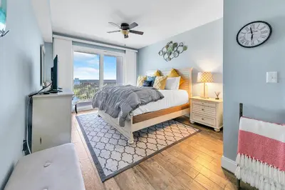 a bedroom with a bed and a clock on the wall at Laketown Wharf 1829 by Emerald Coast Retreats in Panama City Beach