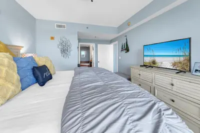 a bedroom with a large bed with a flat screen tv at Laketown Wharf 1829 by Emerald Coast Retreats in Panama City Beach