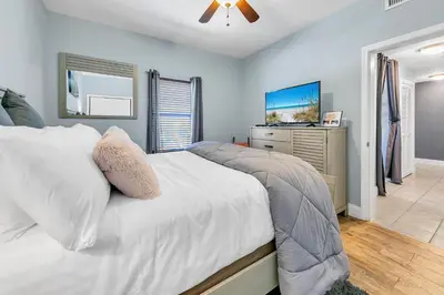 a bedroom with a bed and a dresser with a tv at Laketown Wharf 1829 by Emerald Coast Retreats in Panama City Beach