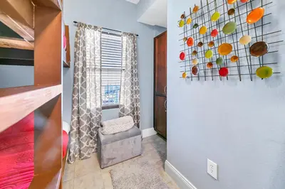 a room with a chair and a painting on the wall at Laketown Wharf 1829 by Emerald Coast Retreats in Panama City Beach