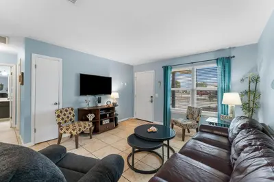 a living room with a couch and a tv at Beach Hideaway in Panama City Beach