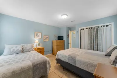 a bedroom with two beds and a dresser at Beach Hideaway in Panama City Beach