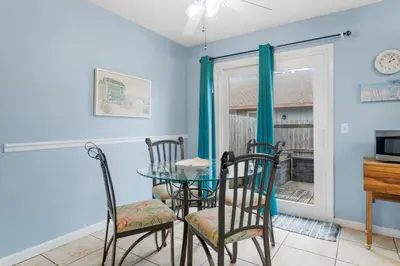 a dining room with a table and chairs and a window at Beach Hideaway in Panama City Beach