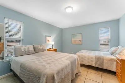 a bedroom with two beds and two windows at Beach Hideaway in Panama City Beach