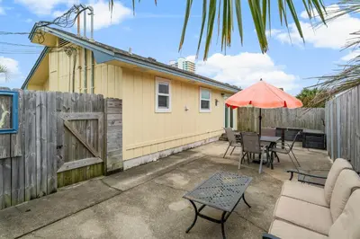 a patio with a table and an umbrella at Beach Hideaway in Panama City Beach