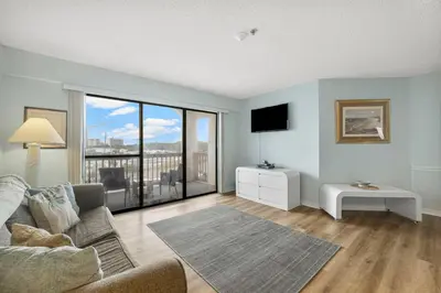 a living room with a couch and a large window at The Inn At St Thomas Square #1305A in Panama City Beach