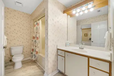 a bathroom with a toilet and a sink and a mirror at The Inn At St Thomas Square #1305A in Panama City Beach