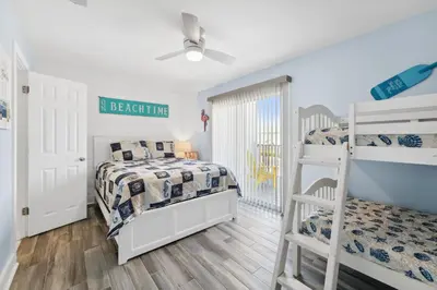 a bedroom with two bunk beds and a window at Mimi's Beach Bungalow in Panama City Beach