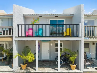 a house with a balcony with chairs on it at Mimi's Beach Bungalow in Panama City Beach
