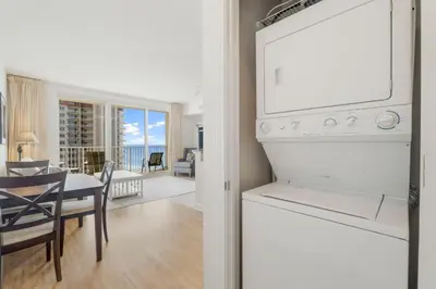 a kitchen with a white refrigerator and a dining room at Shores Of Panama #1509 in Panama City Beach