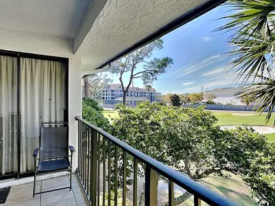 a balcony with a chair and a view of a golf course at Edgewater Villa #2012 in Panama City Beach